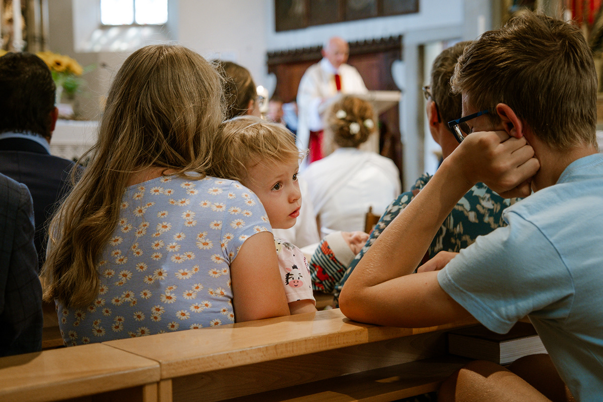Emotionale Hochzeitsgäste sitzen während der Trauung in der Kirche