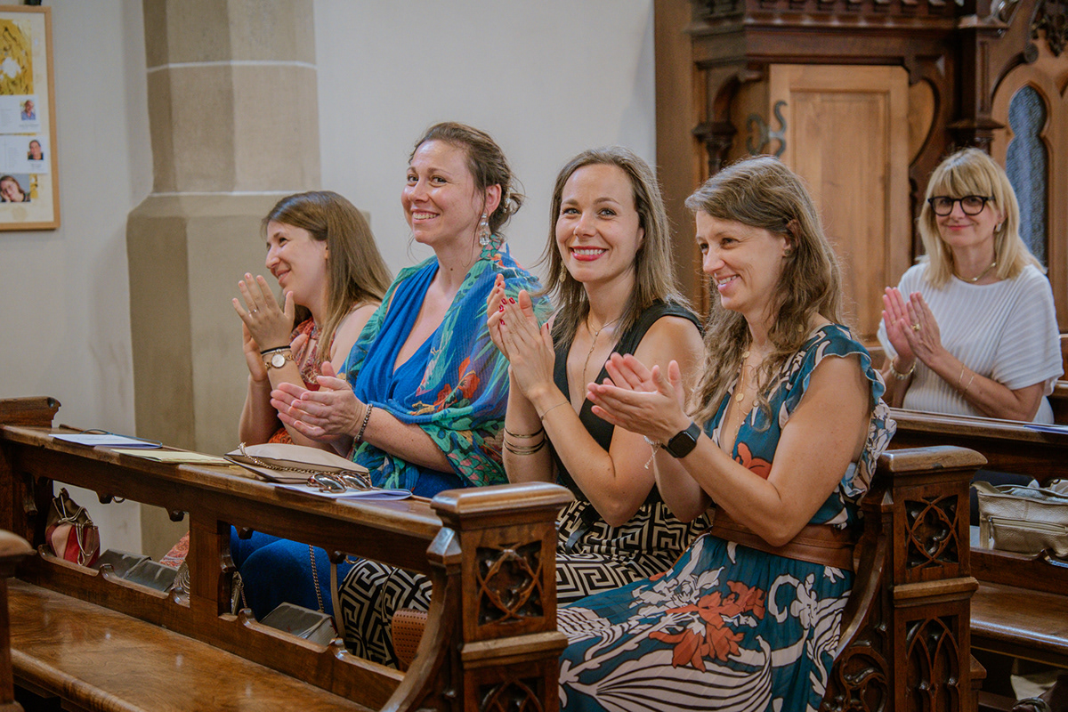 Hochzeitsgäste sitzen emotional bewegt in der Kirche