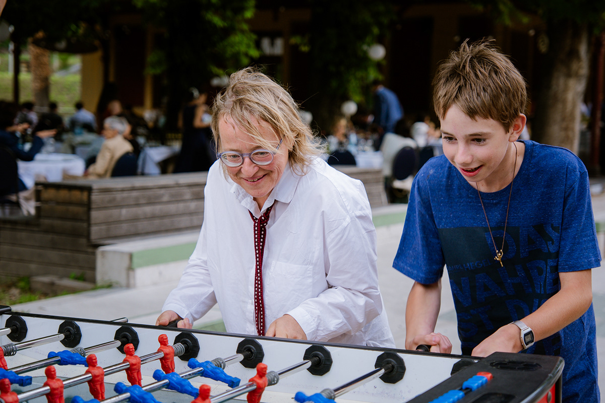 Hochzeitsgäste und Kinder spielen gemeinsam Tischfußball